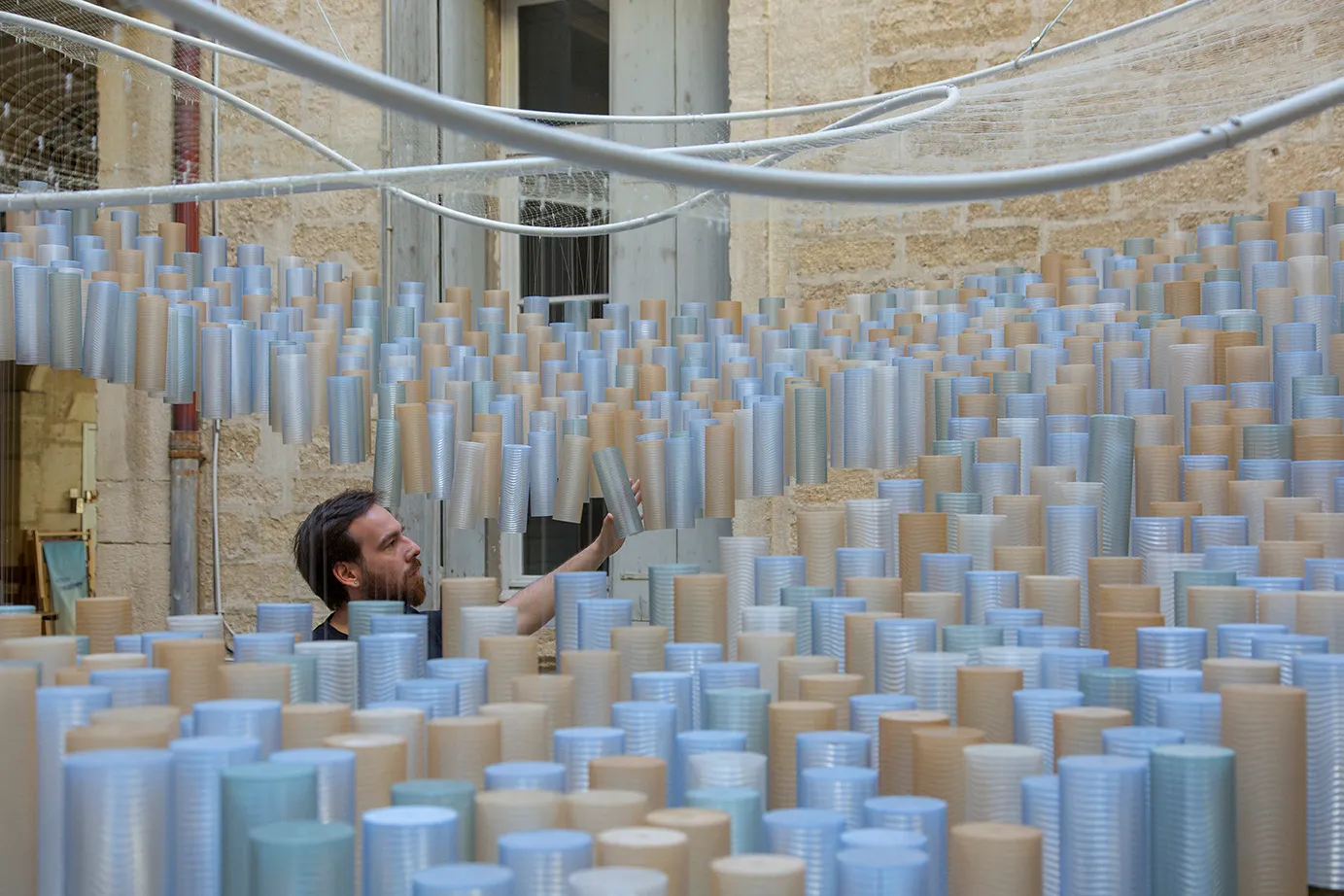 Un visiteur au milieu des modules cylindriques suspendus de RHUBARB